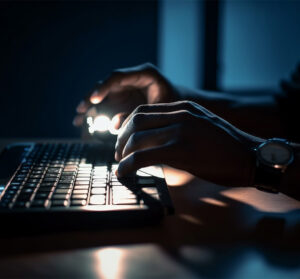 Pessoa digitando no teclado de um notebook.